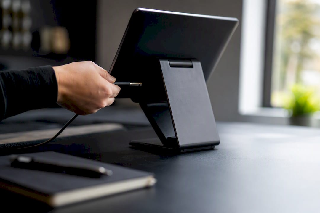 Hand plugging charger into POS device